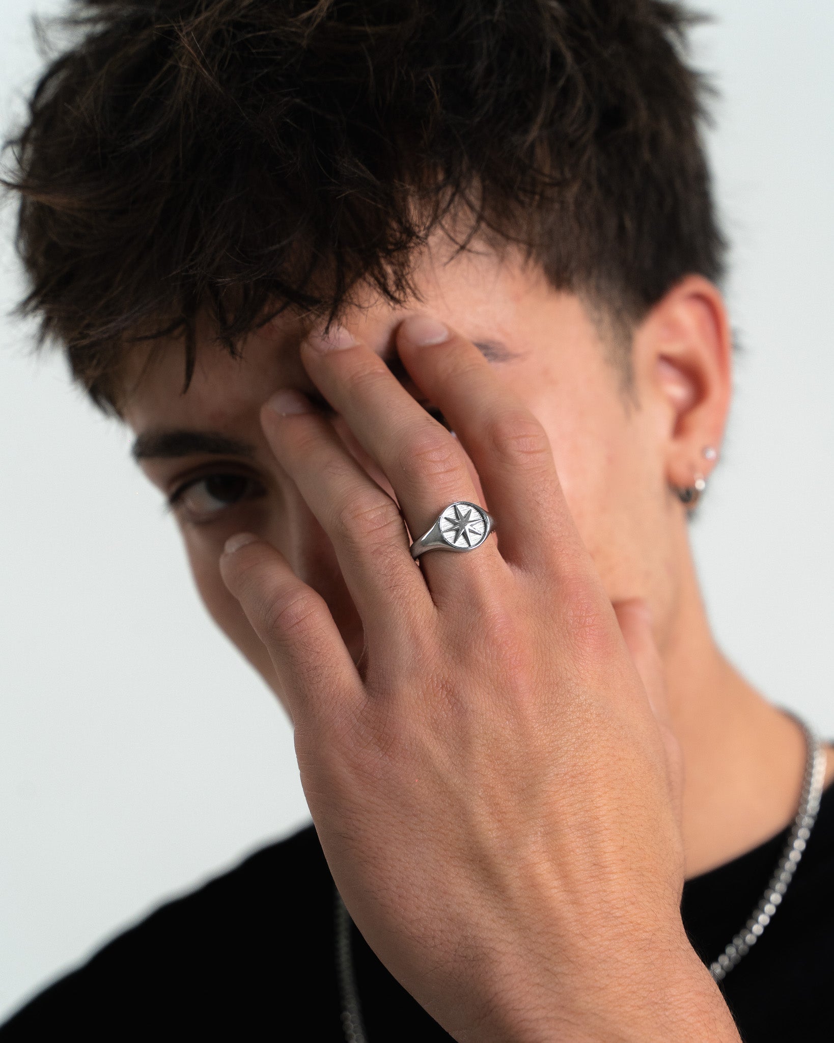 Close-up of STAR SILVER RING on a man's finger showing a clean, stackable design.