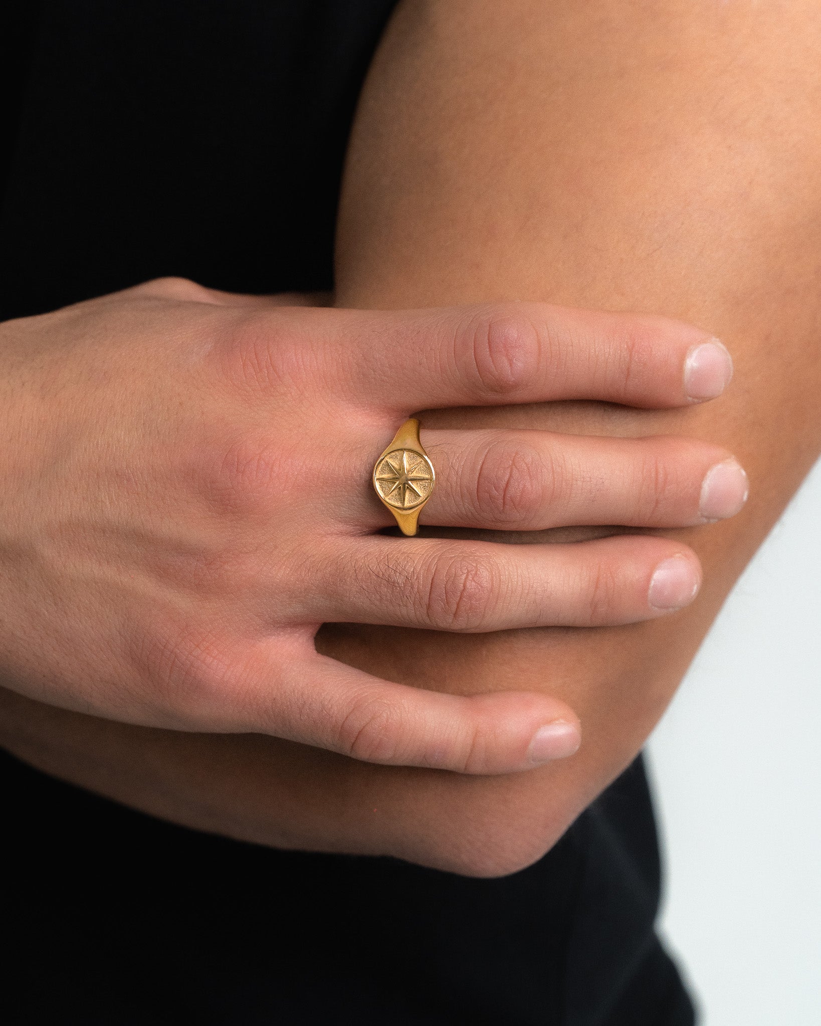 Close-up of gold star ring on finger highlighting the star motif