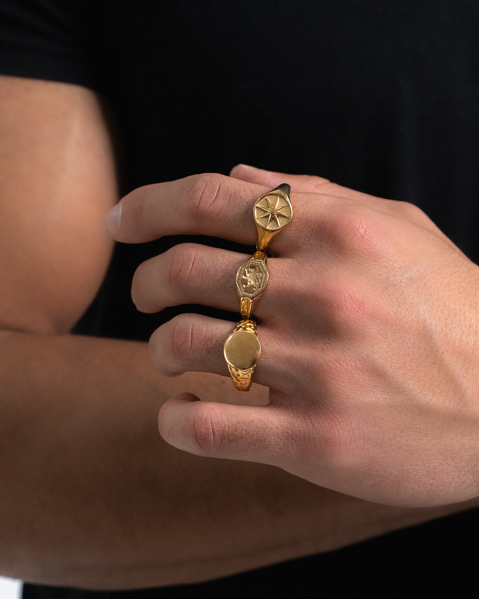 Legacy Gold Ring worn on finger with a round face featuring a starburst design