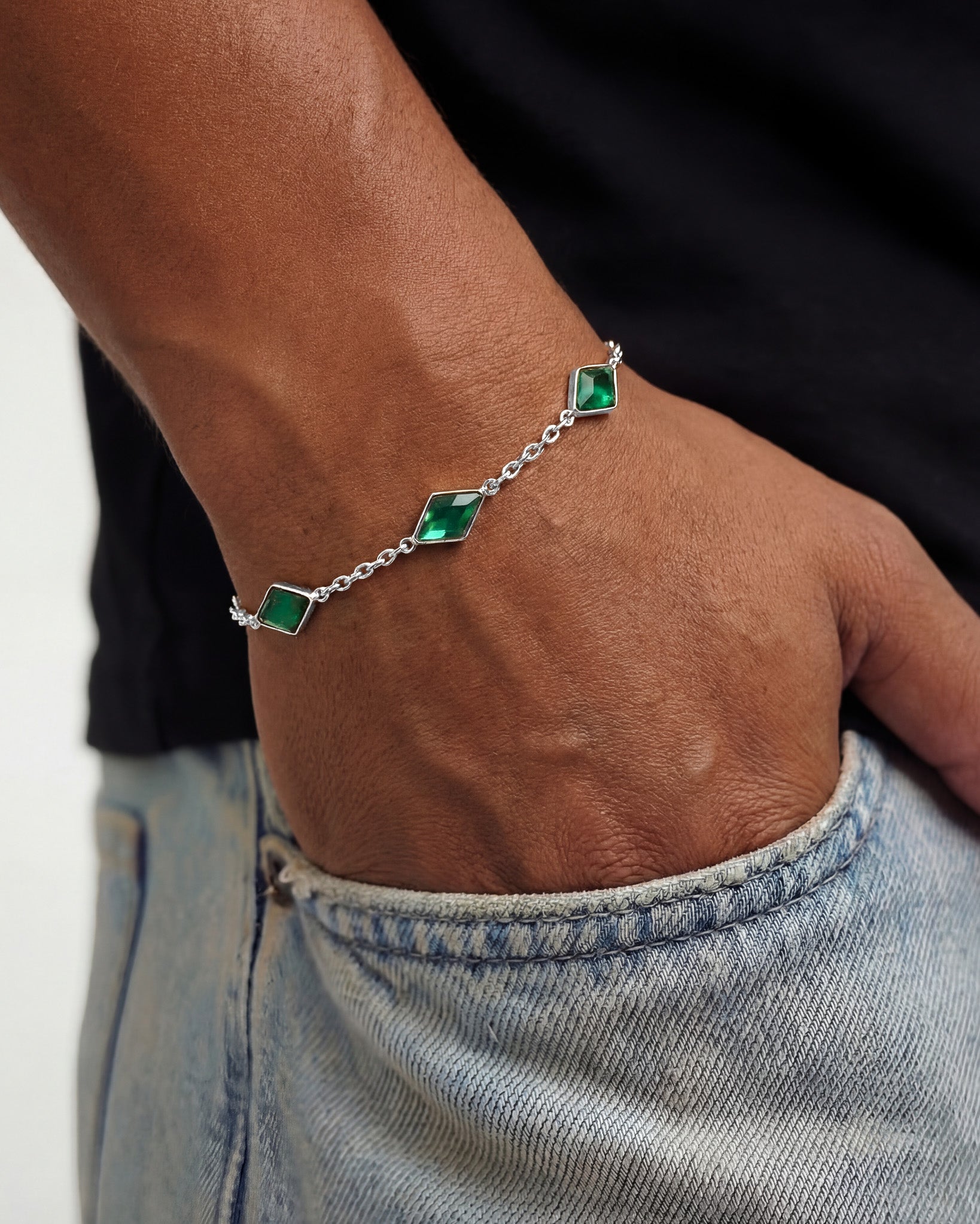 Amberes silver bracelet with diamond shaped emerald green stones on a silver chain worn on the wrist