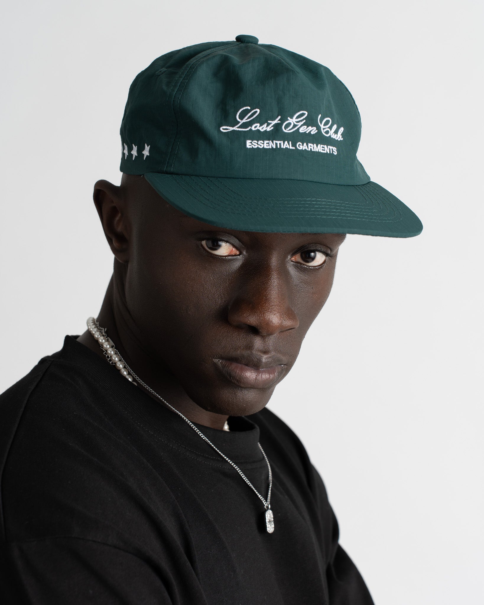 Primer plano de gorra verde de nailon con bordado Lost Gen Club Essential Garments