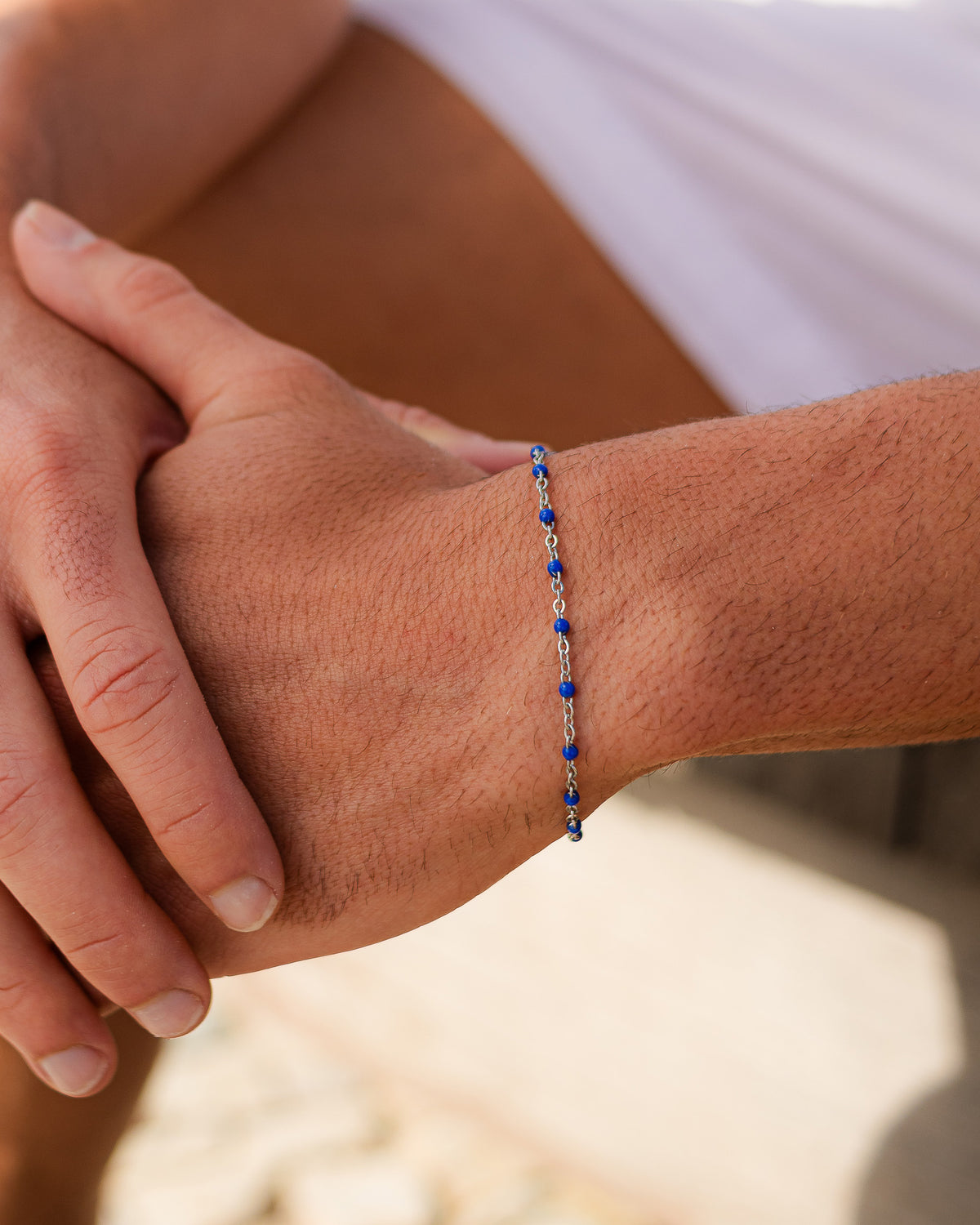 Pulsera de plata con cuentas azules en la muñeca