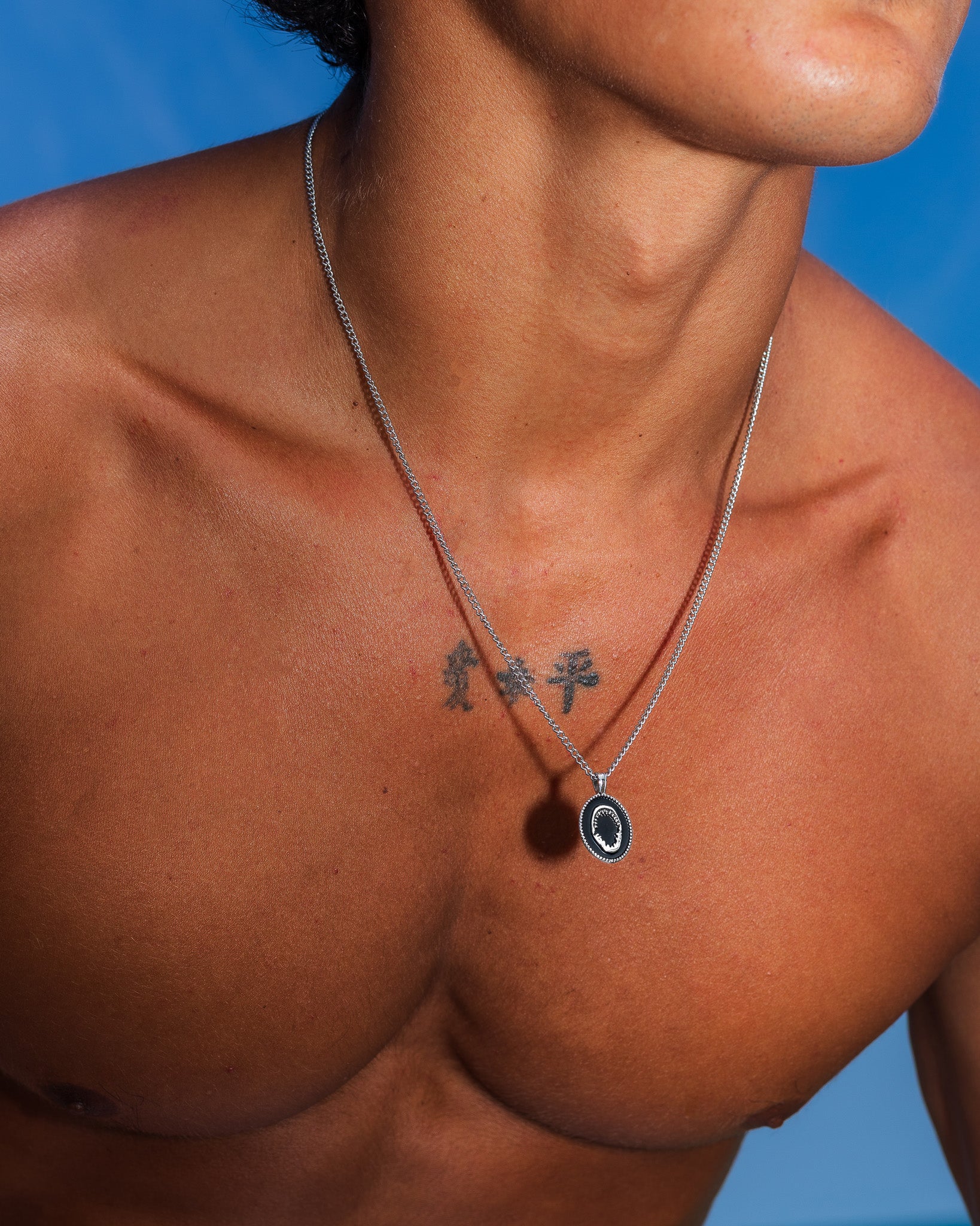 Primer plano del collar LOMBOK de plata en el cuello, con colgante redondo