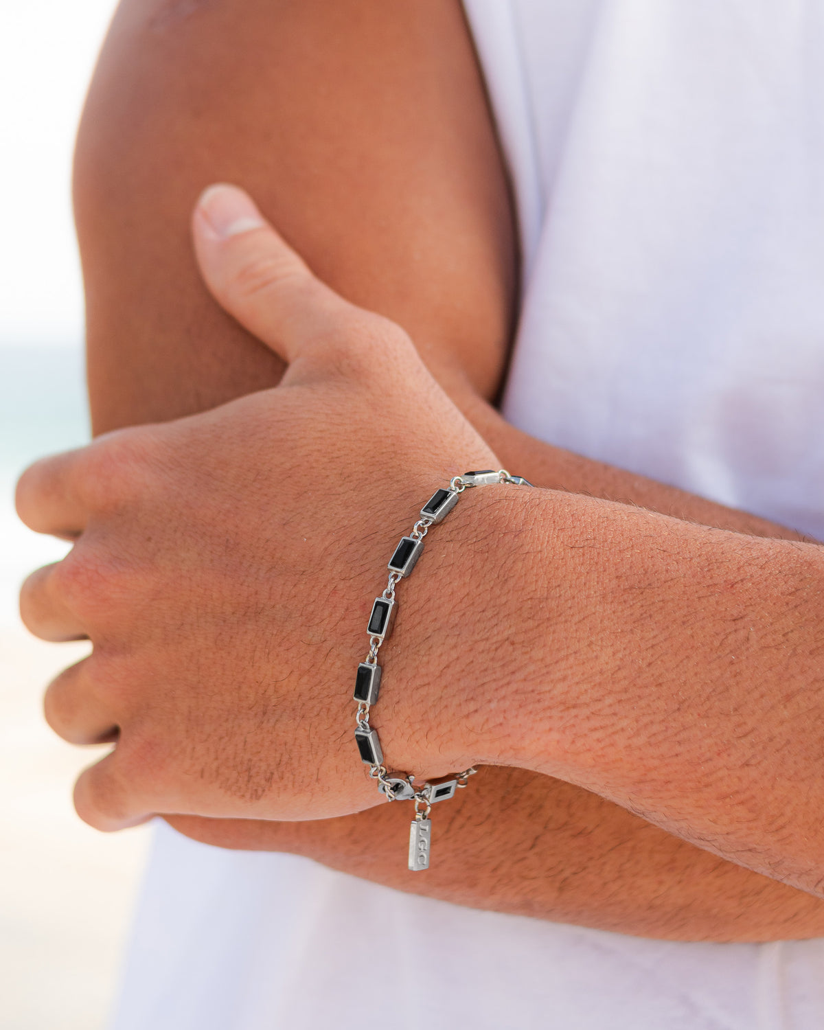 Pulsera OMEN de plata con piedras negras rectangulares en la muñeca