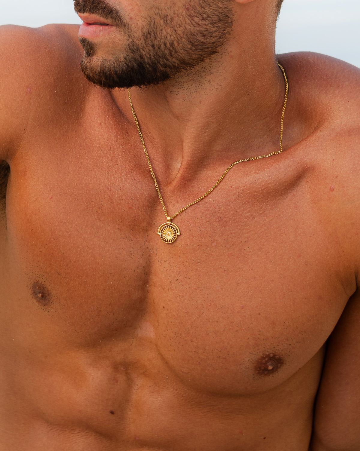 Collar SIRA de oro con cadena fina apoyado en el cuello de un hombre