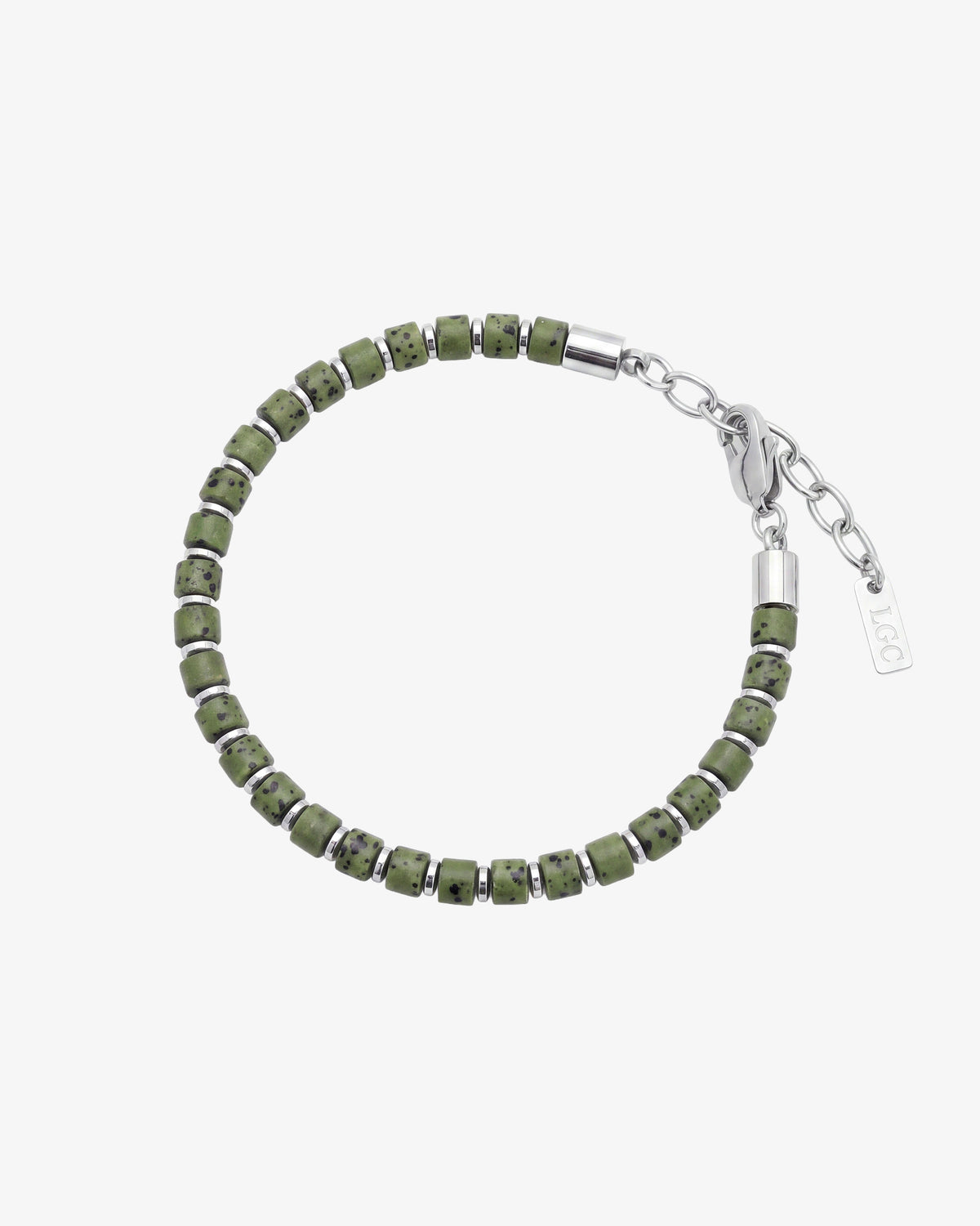 Pulsera de piedra de lava verde con pequeños separadores de plata en la muñeca de un hombre.