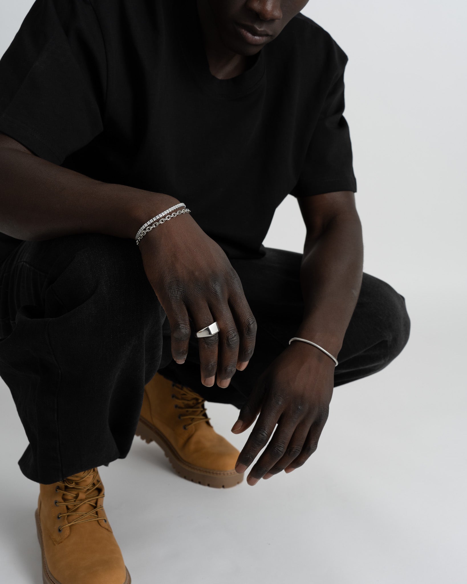 Model's hand wearing a faceted prism silver ring with a sharp profile