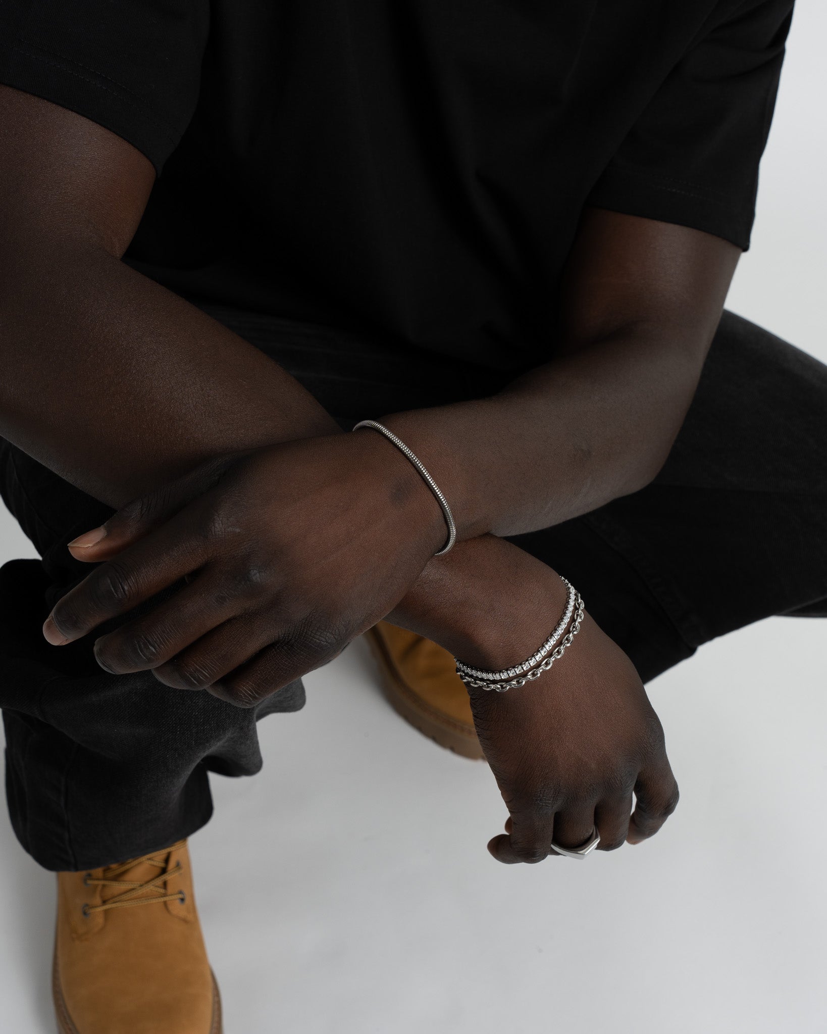 Close up of Sunset silver bracelets stacked on the wrist showing the stone band and chain link