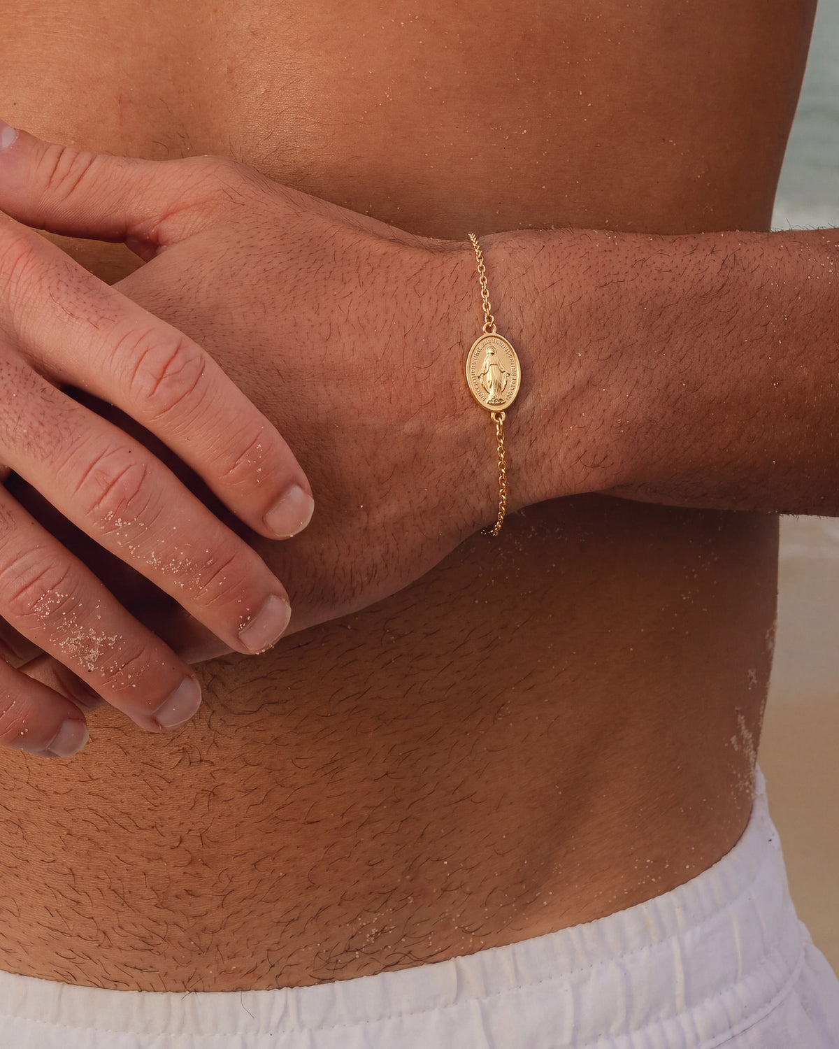 Wrist view of the gold Virgin Mary bracelet with oval medallion.