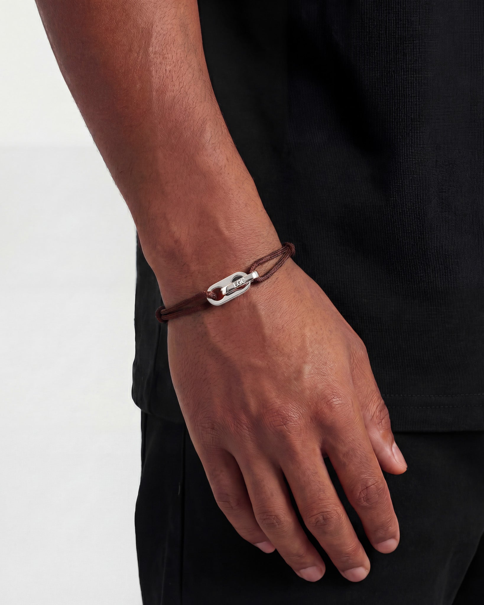 Atlantis silver bracelet on brown cord with adjustable clasp worn on the wrist
