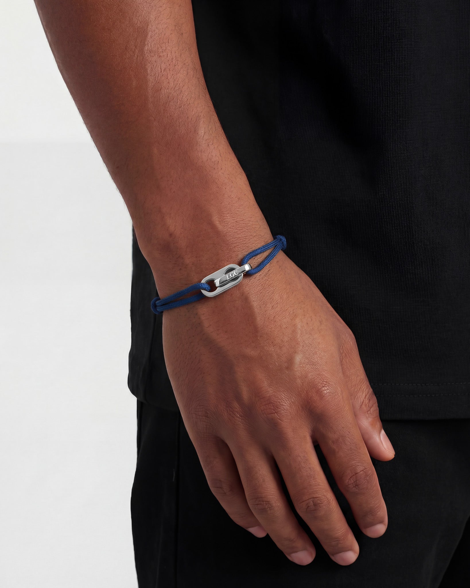 Close up of Atlantis silver bracelet on brown cord around the wrist showing the clasp