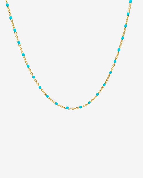 Gold chain necklace with turquoise beads displayed on a white background