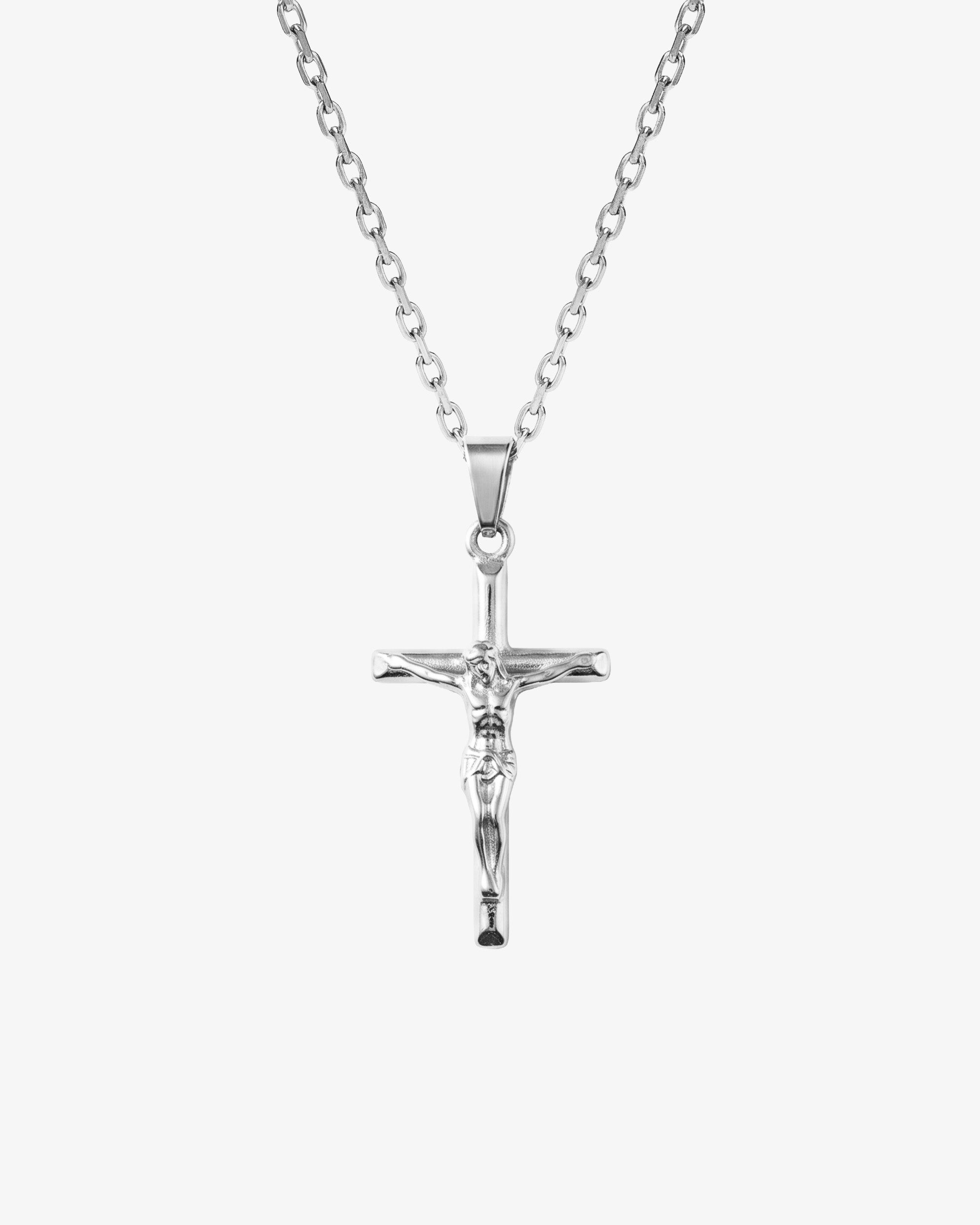 Colgante de crucifijo de plata sobre cadena y fondo claro