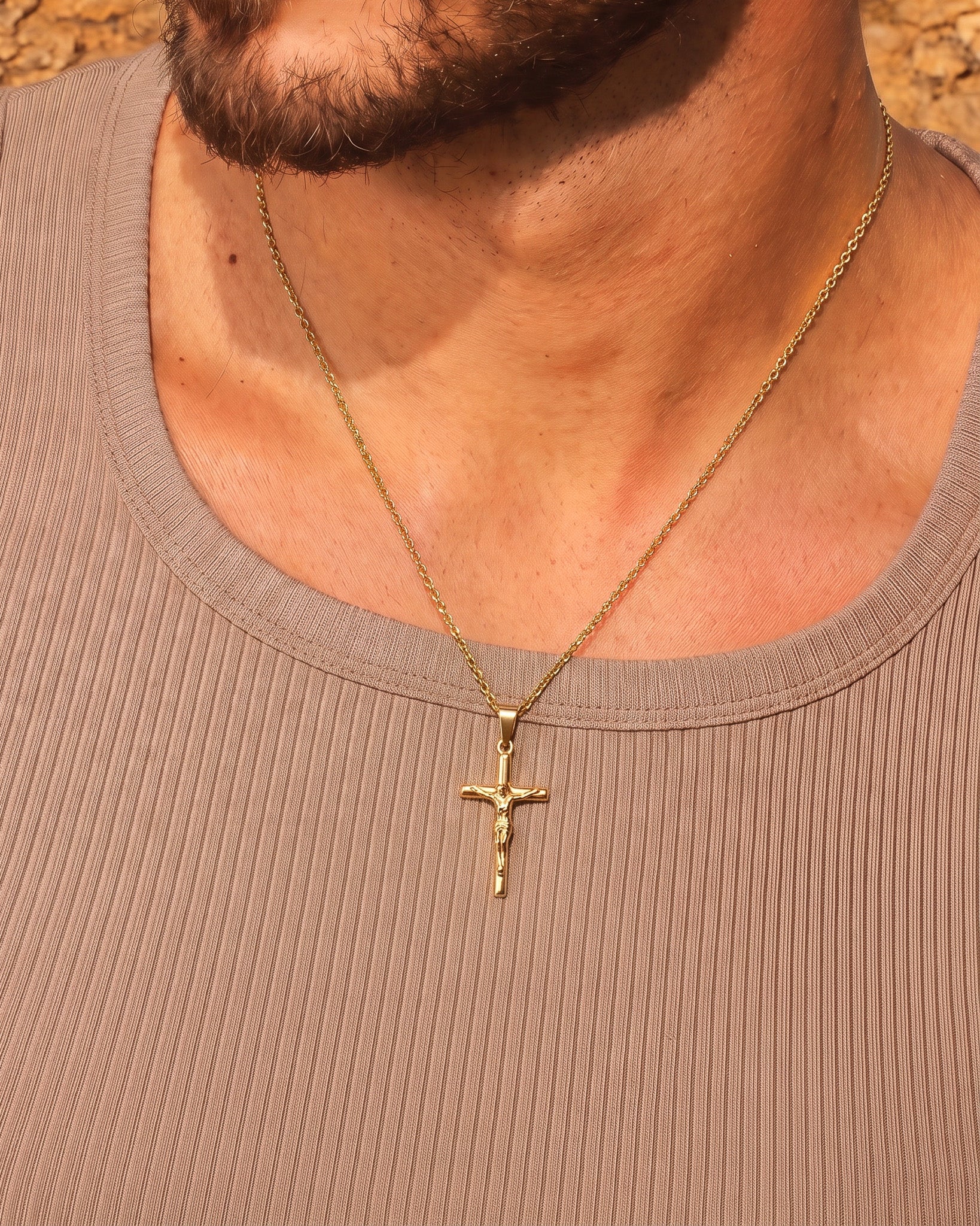 Collar de oro con crucifijo en el cuello, con la cadena a la vista