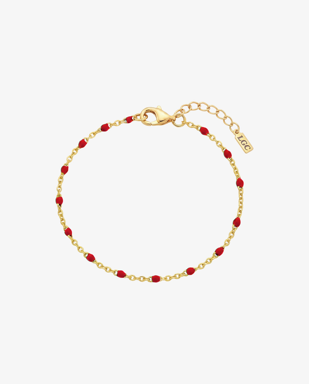 Pulsera dorada con cuentas rojas y cierre de mosquetón en la muñeca