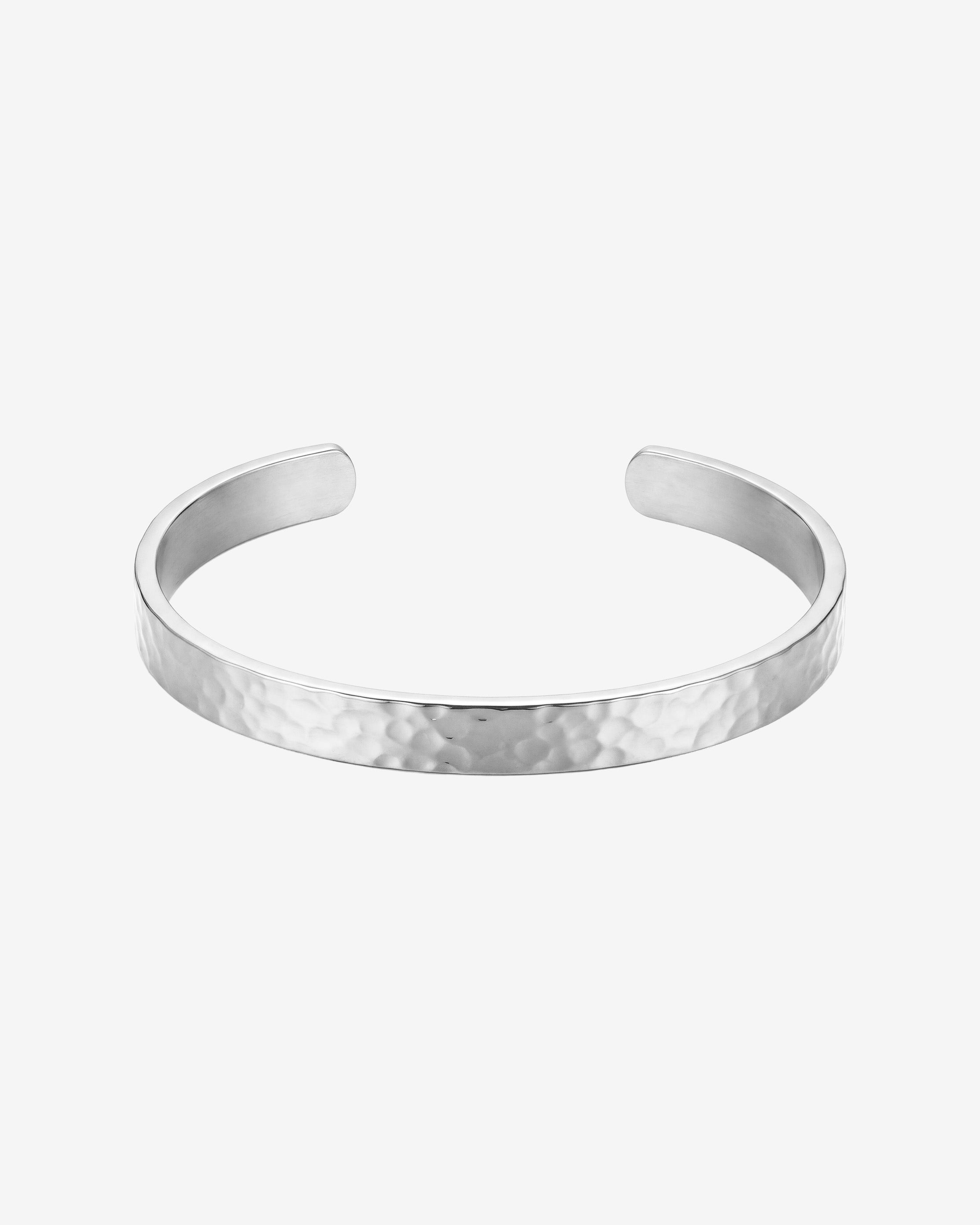 Hammered silver bracelet on a man's wrist with a textured band