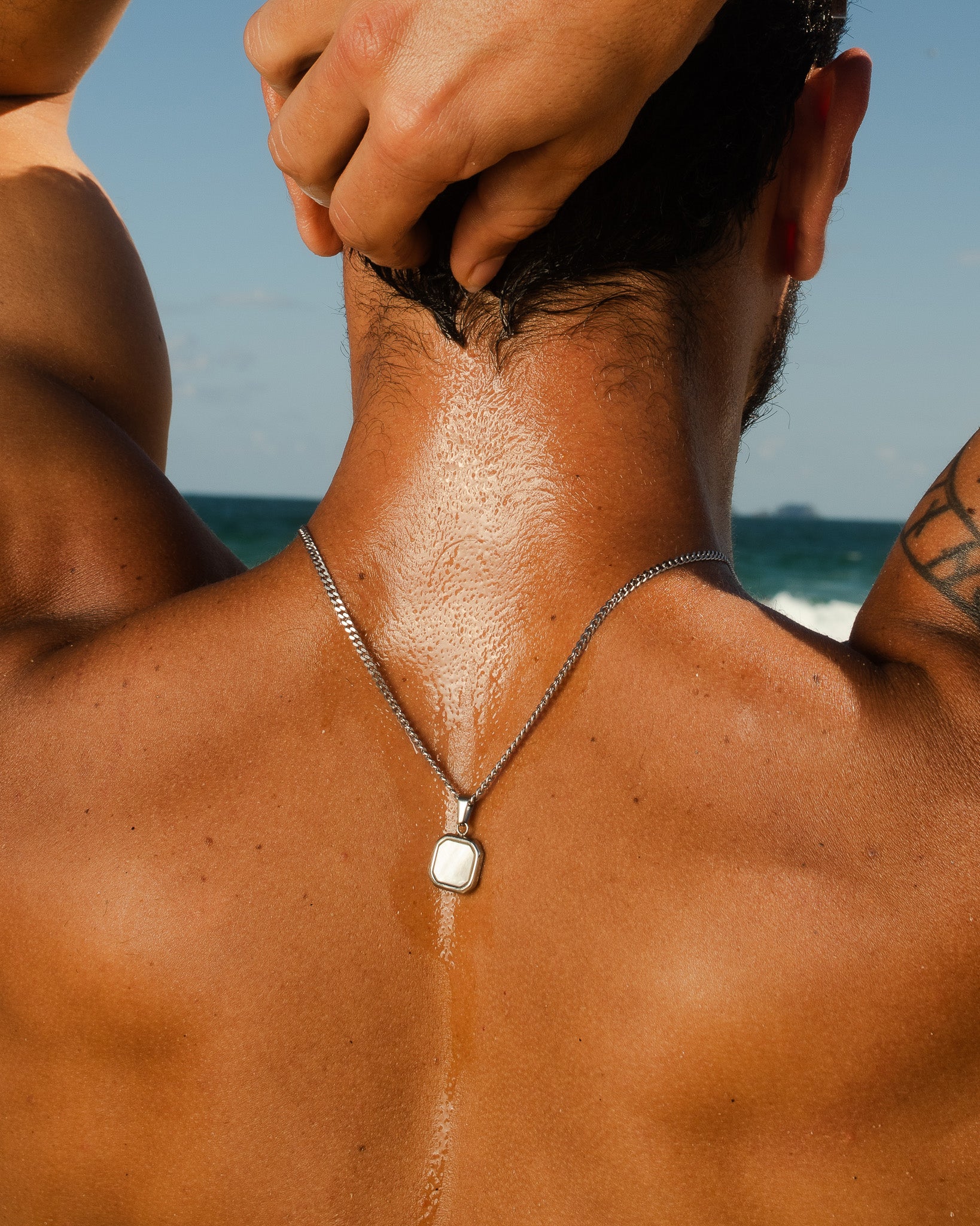 Back of neck close-up showing Nova Silver Necklace chain and square pendant