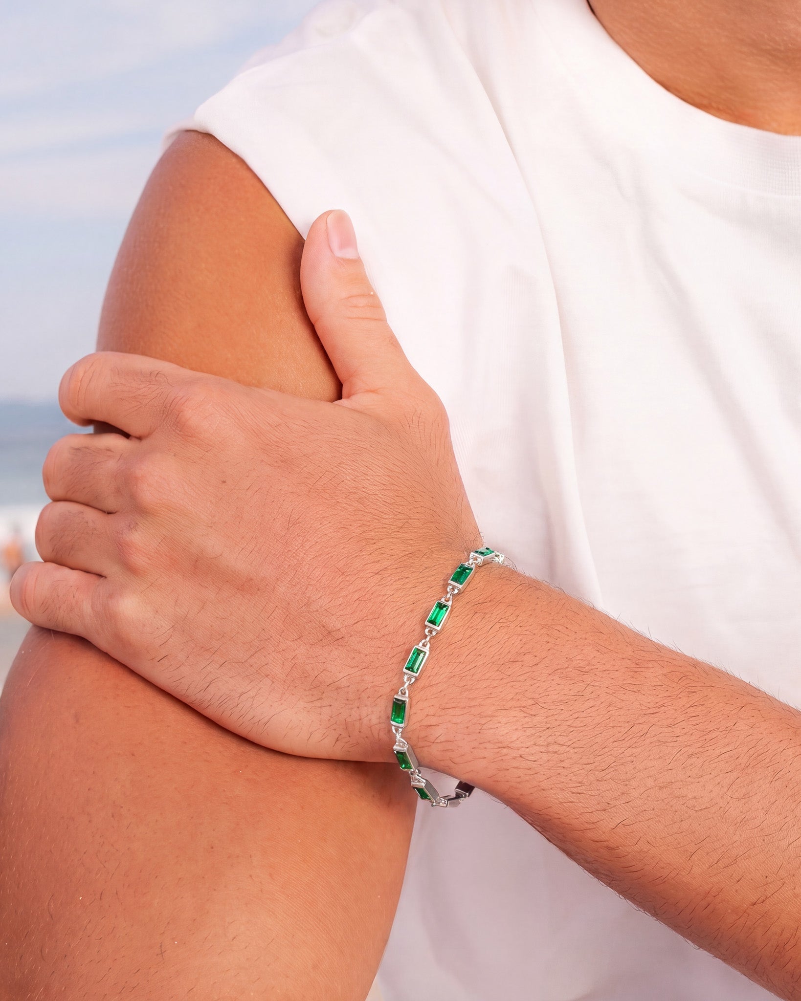 Pulsera de oro con piedras rectangulares rojas unidas por segmentos de oro en la muñeca